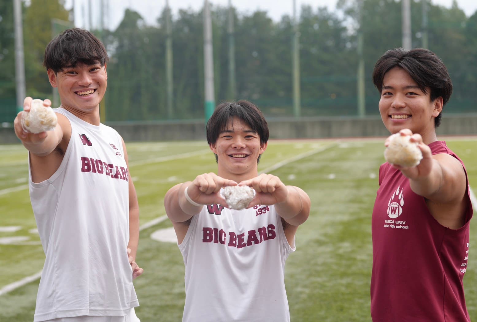 おにぎりを差し出す3人の選手