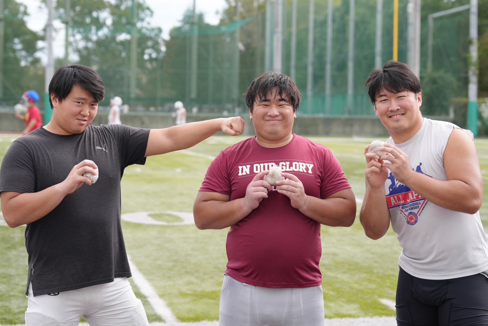 おにぎりを手に並ぶ3人の選手